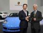 Szef Porsche Michael Macht (po lewej) przekazuje symboliczną kierownicę swojemu następcy Matthiasowi Muellerowi